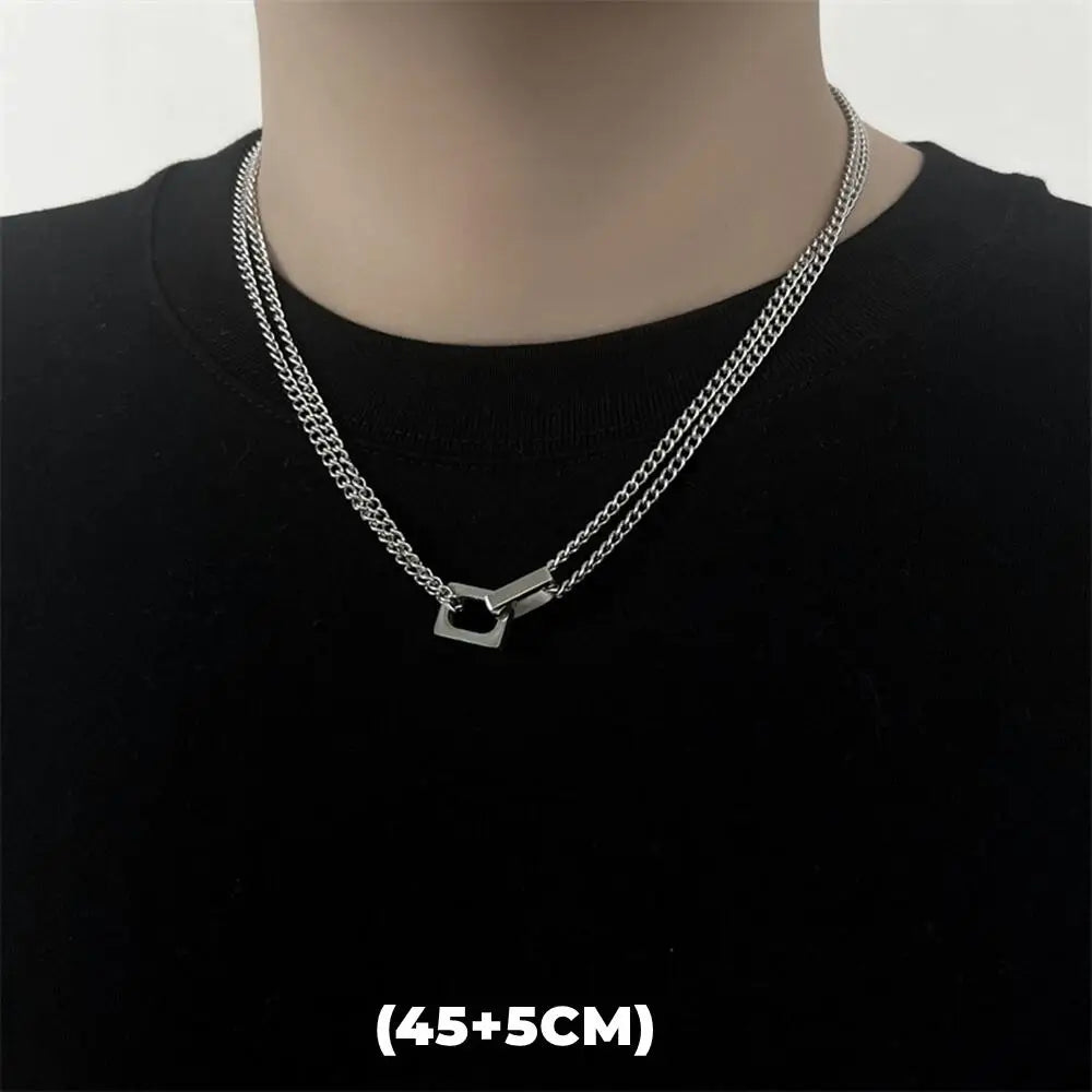 Silver double-layer chain necklace with a star pendant worn against a black shirt.