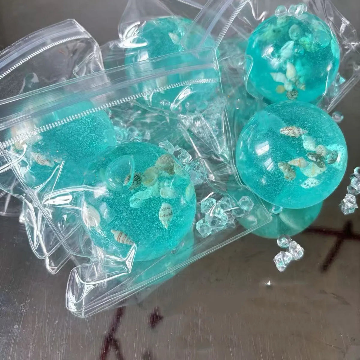 Clear plastic bags filled with glowing turquoise ocean squishy stress balls containing small sea life