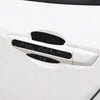 Close-up of a white car door handle with black scratch protection stickers applied.