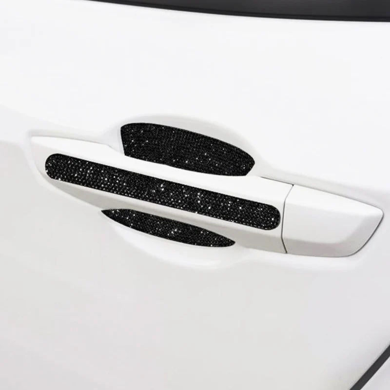 Close-up of a white car door handle with black scratch protection stickers applied.
