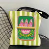 A canvas tote bag featuring a colorful illustration of sardines for toasts on a striped background.