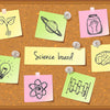 A collection of colorful sticky notes featuring science-related drawings and diagrams pinned to a brown board.