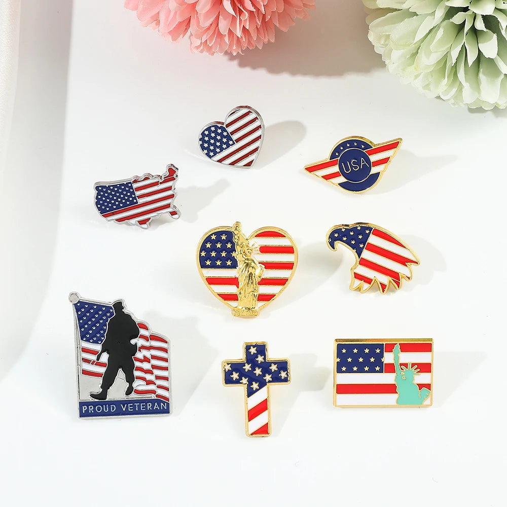 A collection of enamel pins featuring American flag designs, including stripes, stars, and patriotic symbols.