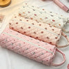 Three pink quilted cotton hair dryer storage bags lined up on a white surface.