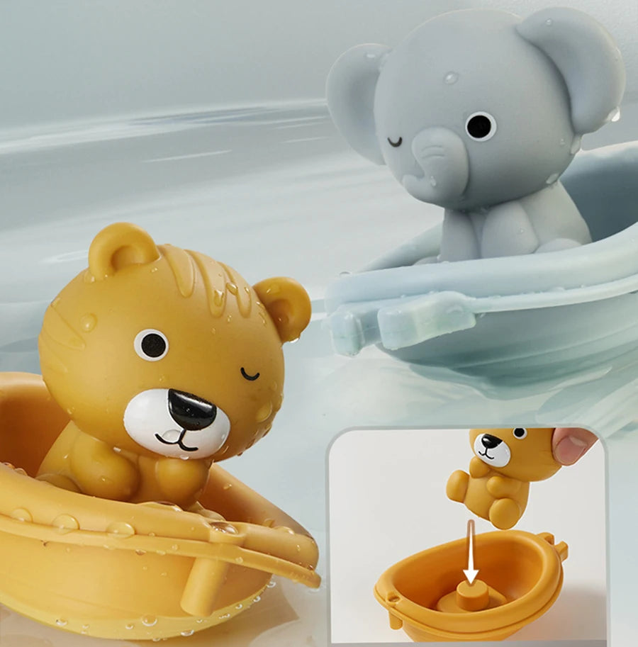 A yellow lion silicone finger puppet bath toy is shown next to a gray elephant bath toy.