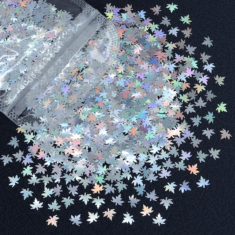 A close-up view of shiny holographic star sequins scattered on a dark surface.