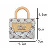 A mini floral textured crossbody tote bag in white and purple with a beige handle and square silver hardware.