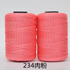Two spools of bright coral pink 3-ply polyester knitting yarn for crochet and hand crafts