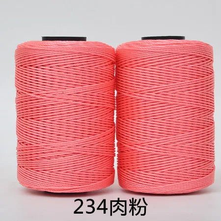 Two spools of bright coral pink 3-ply polyester knitting yarn for crochet and hand crafts