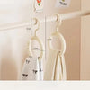 A white Nordic wall-mounted organizer hook displaying a hat and scarf hanging on a light-colored shelf.