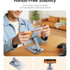 A person is using a hands-free phone stand on a wooden table, demonstrating its stability and low-center-of-gravity design.