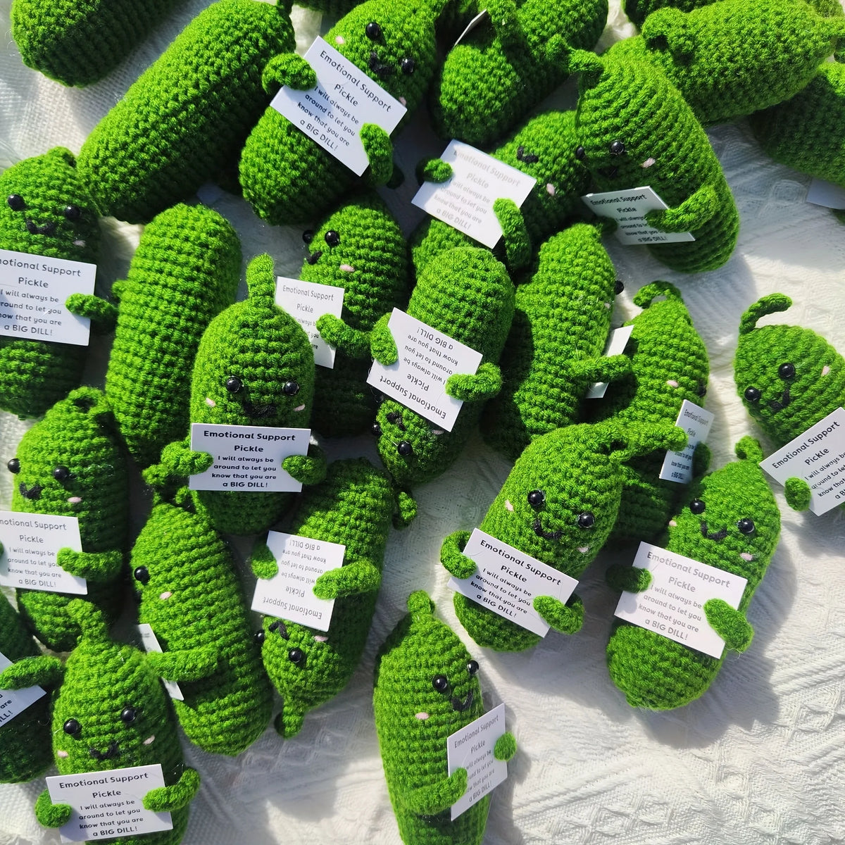 Handcrafted pickle plush toys with muppet faces in various shades of green