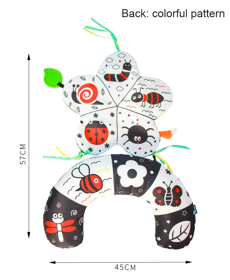 A black and white high contrast tummy time pillow featuring various animal patterns like bees, spiders, and ladybugs.