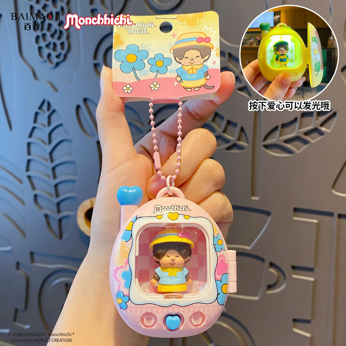 Porte-clés sac à dos rose en carton de dessin animé avec une fille souriante et une caractéristique lumineuse, tenu par une m