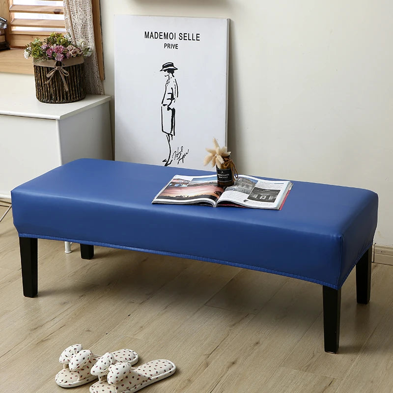 A blue waterproof PU stretch bench cover is placed on a wooden bench, with a magazine and a drawing displayed nearby.