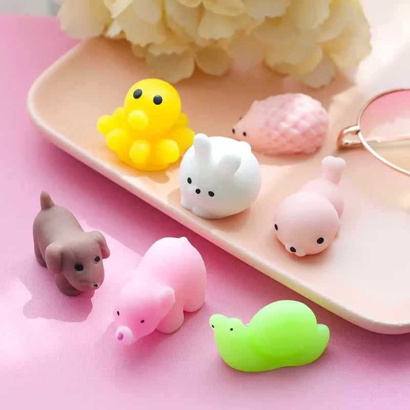 A collection of 18 small, squishy animal stress relief toys in various colors like yellow, pink, and white, arranged on a lig