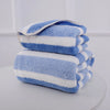 A stack of blue and white striped microfiber towels for bath and face use.