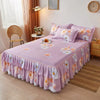 Jupe de lit à motifs floraux roses recouvrant un lit avec des accents blanc et orange.