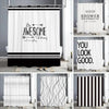 A set of black and white abstract geometric shower curtains displayed in a bathroom setting.