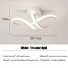 White tri-color LED light fixture with a swirling design mounted on a wall.