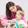 A woman is guiding a baby exploring the world with a sensory tissue box and crinkle scarves.