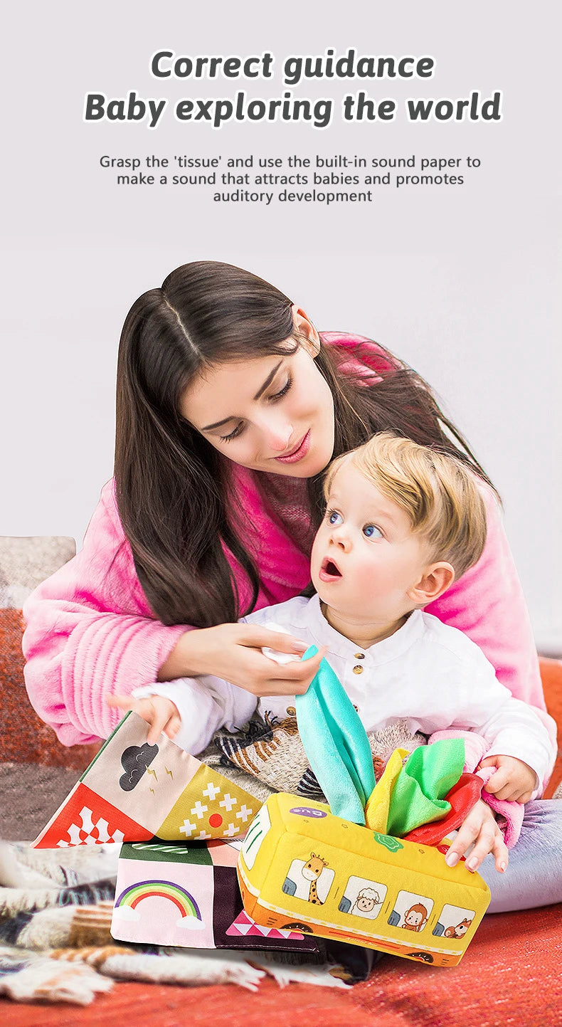 A woman is guiding a baby exploring the world with a sensory tissue box and crinkle scarves.
