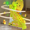 A yellow duck toy climbing a bright green plastic slide with lights and music.
