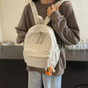 A person is wearing a beige corduroy casual backpack over a brown sweatshirt.