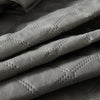 Close-up of a gray quilted waterproof mattress protector with deep pockets.