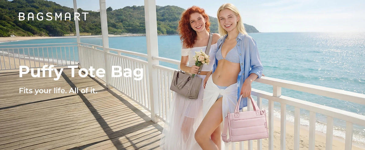 Two women standing on a boardwalk by the sea holding and displaying a puffy tote bag