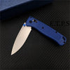 A blue folding pocket knife with a drop point blade resting on a black textured surface.