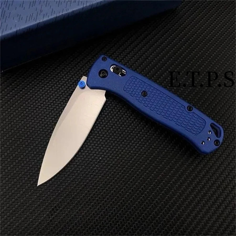 A blue folding pocket knife with a drop point blade resting on a black textured surface.