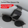 A black carbon fiber glasses clip is shown holding a pair of sunglasses.