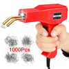 A hand holds a red plastic welding gun with a gold tip, next to several bundles of metal wire.