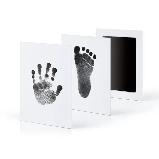 A set of three framed prints showing a handprint and a footprint on white backgrounds.