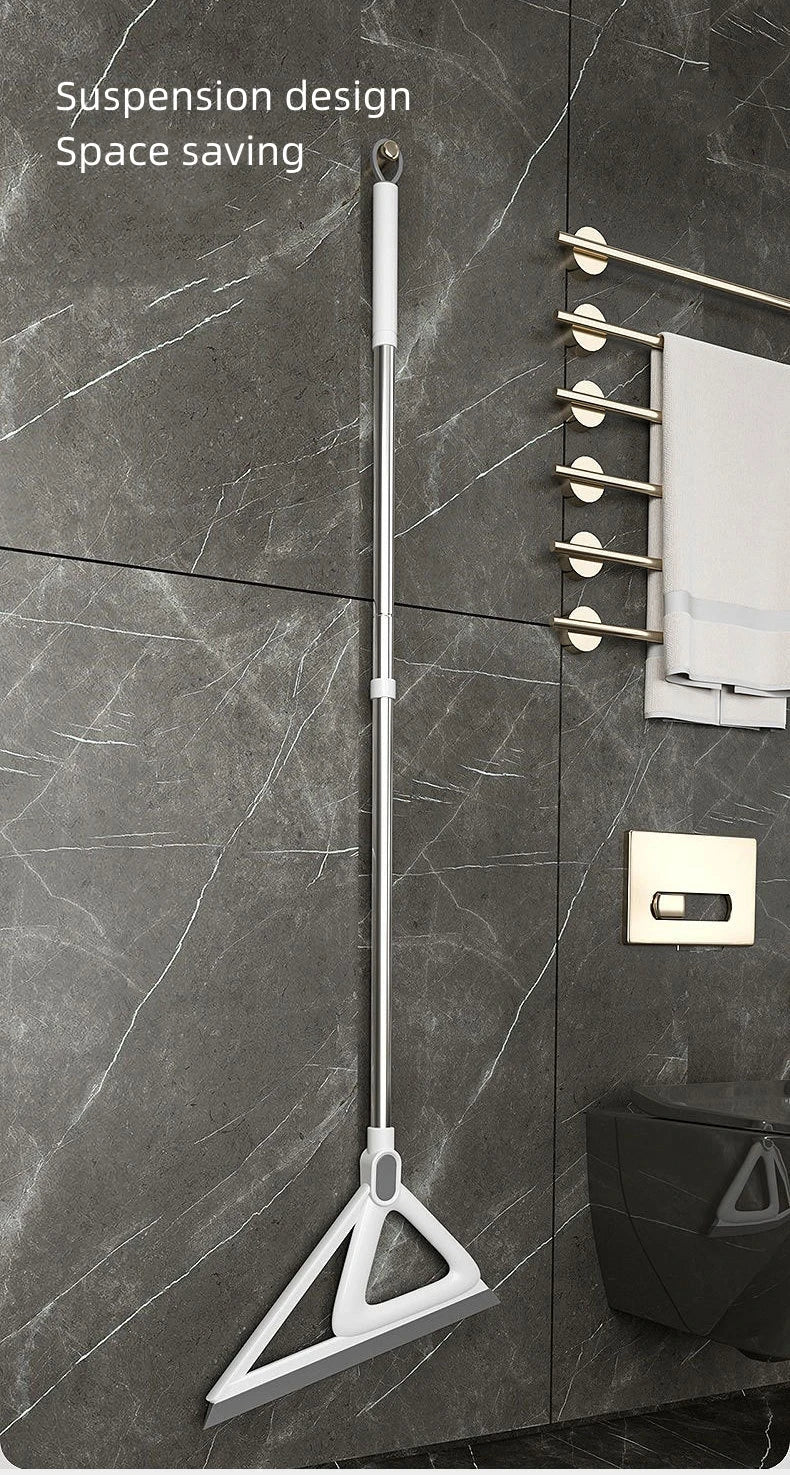 A silver silicone squeegee broom hanging on a wall, demonstrating suspension design and space saving.