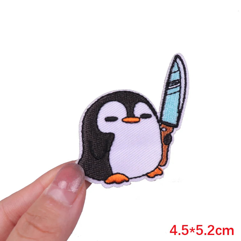 Embroidered iron-on patch of a cartoon penguin with closed eyes and orange feet