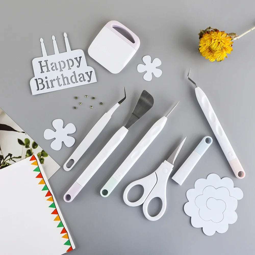 A set of six white vinyl weeding and craft tools, including a spatula, needle, and scissors, arranged on a gray surface.