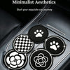Four circular coasters featuring paw prints and camellia flower designs placed in a car cup holder.