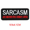 Black embroidered iron-on letter patch with white text saying SARCASM JUST ANOTHER FREE SERVICE I OFFER