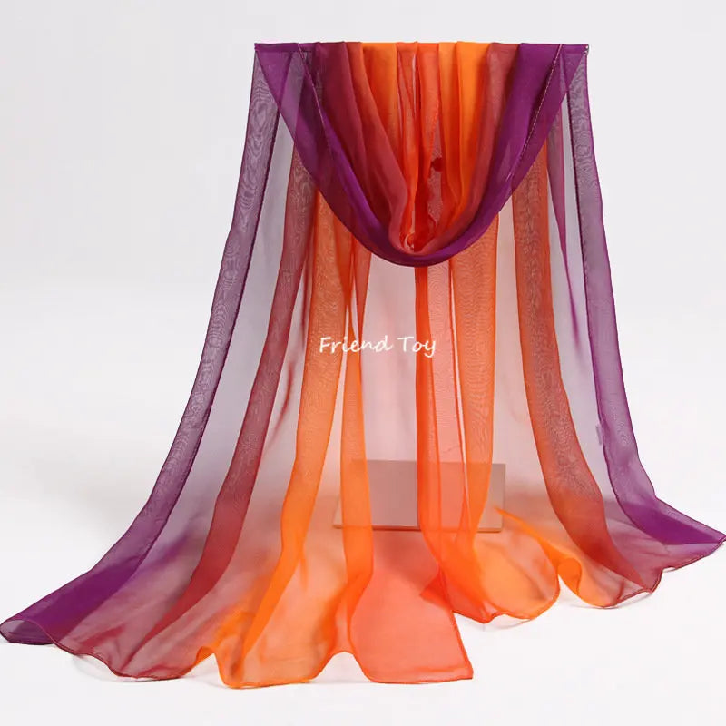 A sheer, flowing fabric in shades of purple, orange, and pink is displayed for imaginative play.