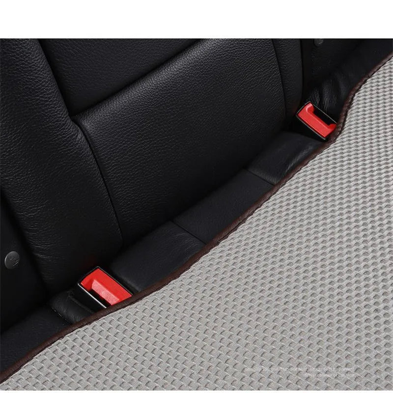 Black leather car seat cushion with red accents shown in a close-up view.