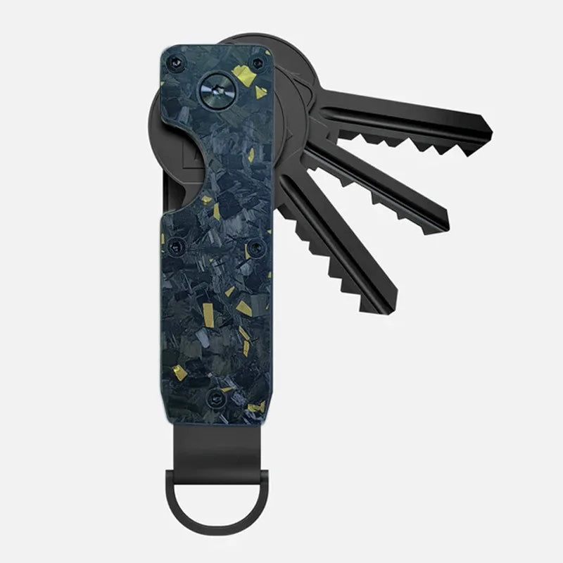 A minimalist aluminum key organizer with a dark blue and gold speckled finish, holding several keys.