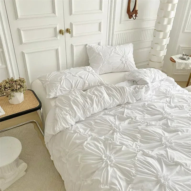 White luxury duvet cover set with a 3D twist floral pinch-pleated pattern displayed on a bed.