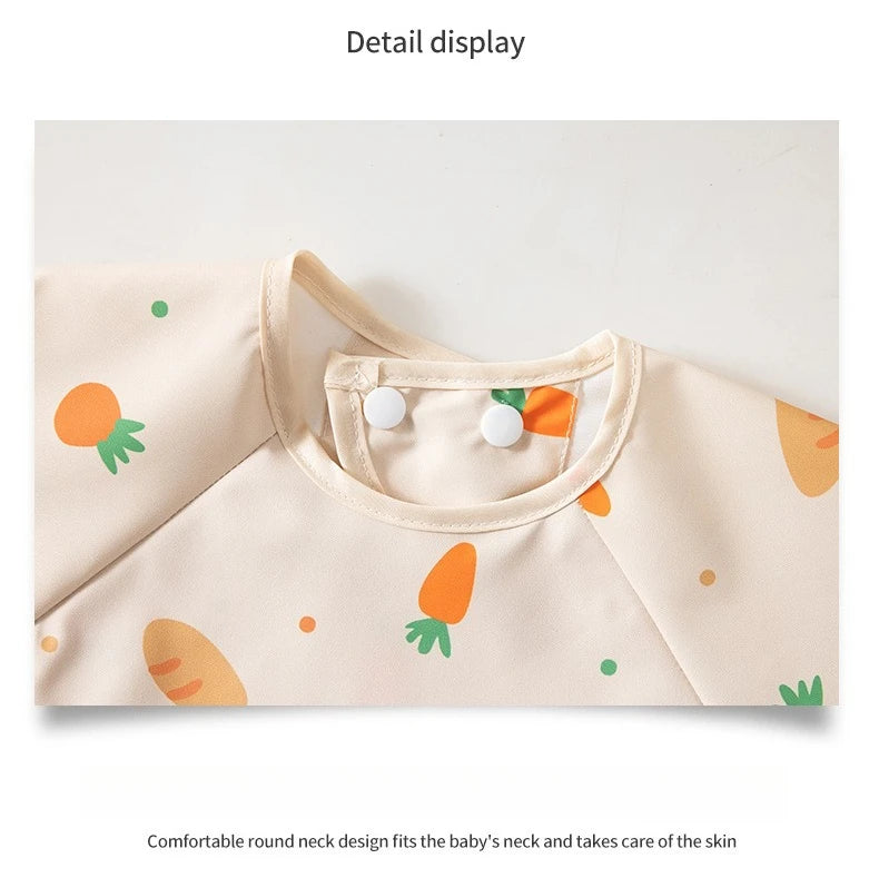 A light beige children's feeding bib with a round neck design and an orange carrot motif.