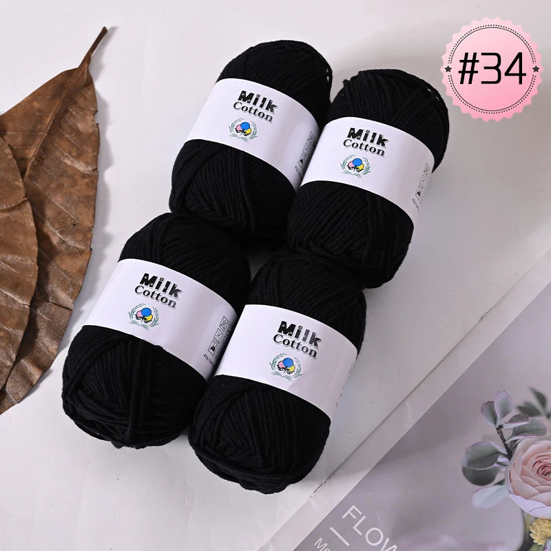 A bundle of black Milk Cotton yarn skeins with white labels and a pink tag marked #34.