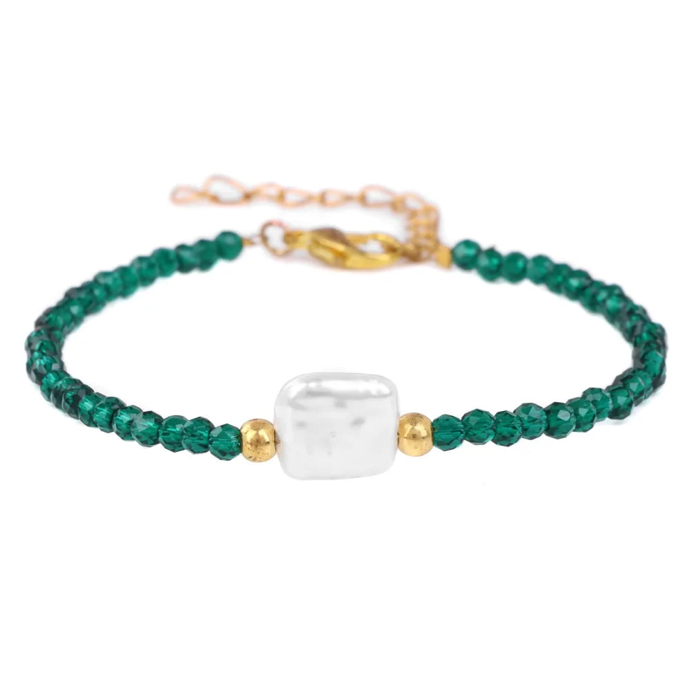 A natural stone bead bracelet featuring green beads and a white square stone with an adjustable gold lace-up closure.