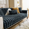 Dunkelgraues Plüschkaninchen-Sofa-Kissen mit strukturiertem Stoff und gelben Akzenten auf einem weißen Sofa.