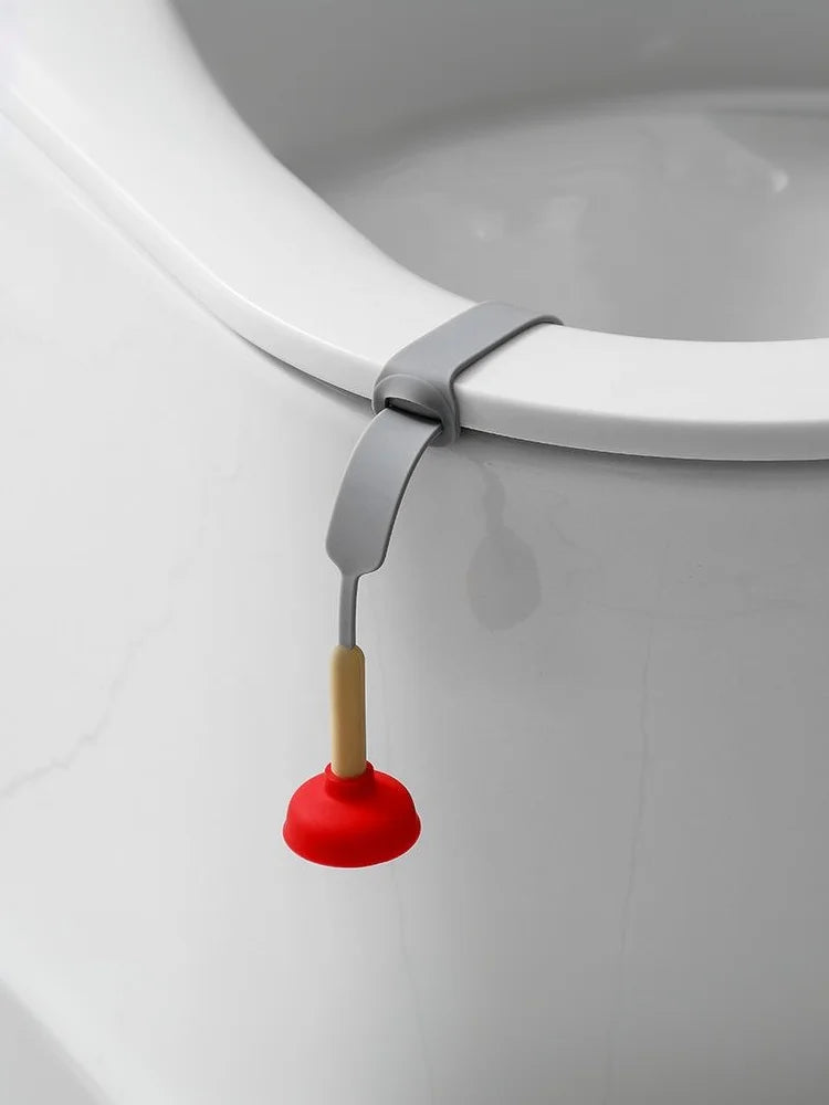 A silver and red hands-free toilet lid lifter attached to a white ceramic toilet rim.