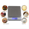 A digital kitchen scale with a stainless steel tray showing a weight of 0.00 grams, surrounded by icons for weighing tea, med